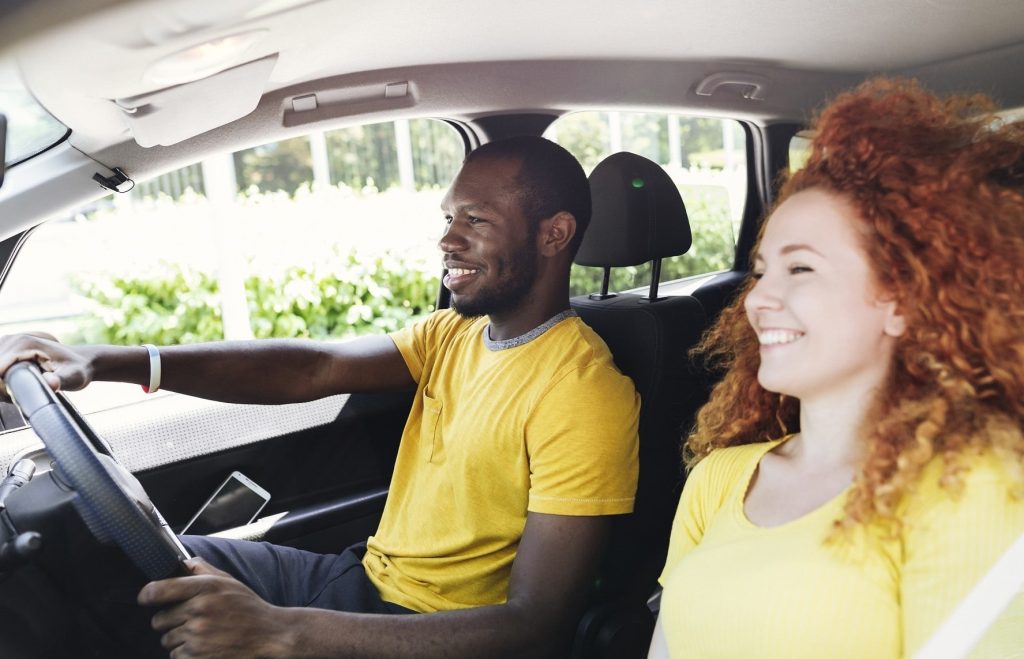 Two friends smiling while driving