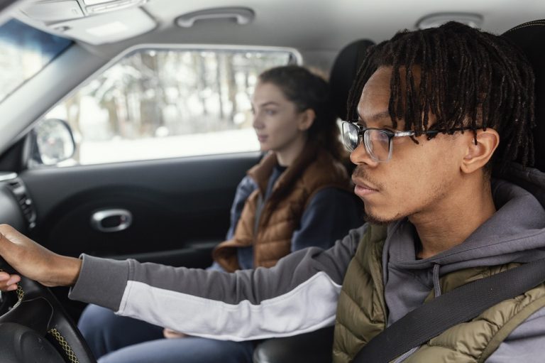 Two people sitting in a car, driving